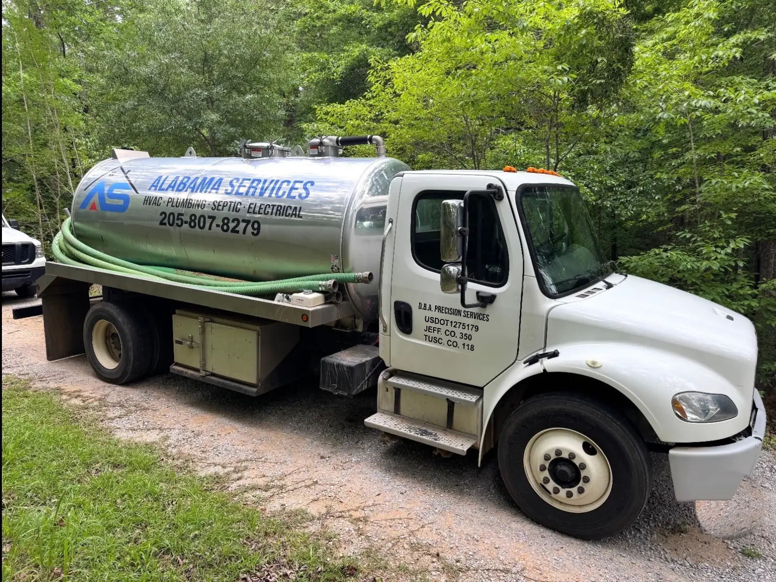 Alabama Septic Tank Services pump truck on a gravel drive in the woods